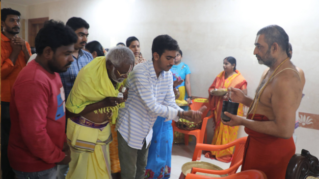 Families receiving divine blessings and sacred Theertham at Theertha Goshti